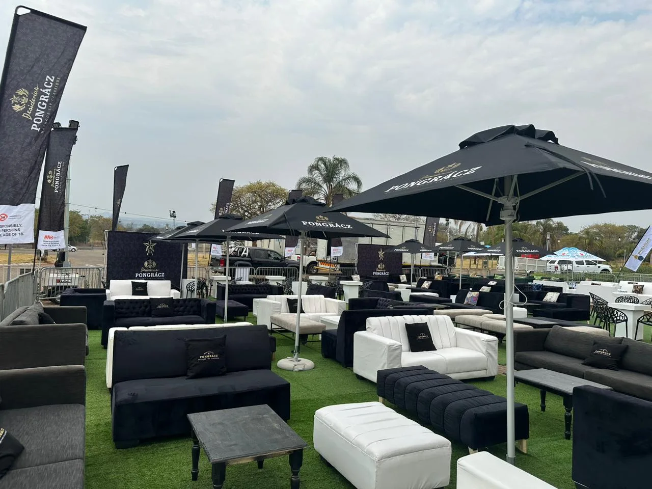 Black, grey and white lounge couches with coffee tables and outdoor umbrellas